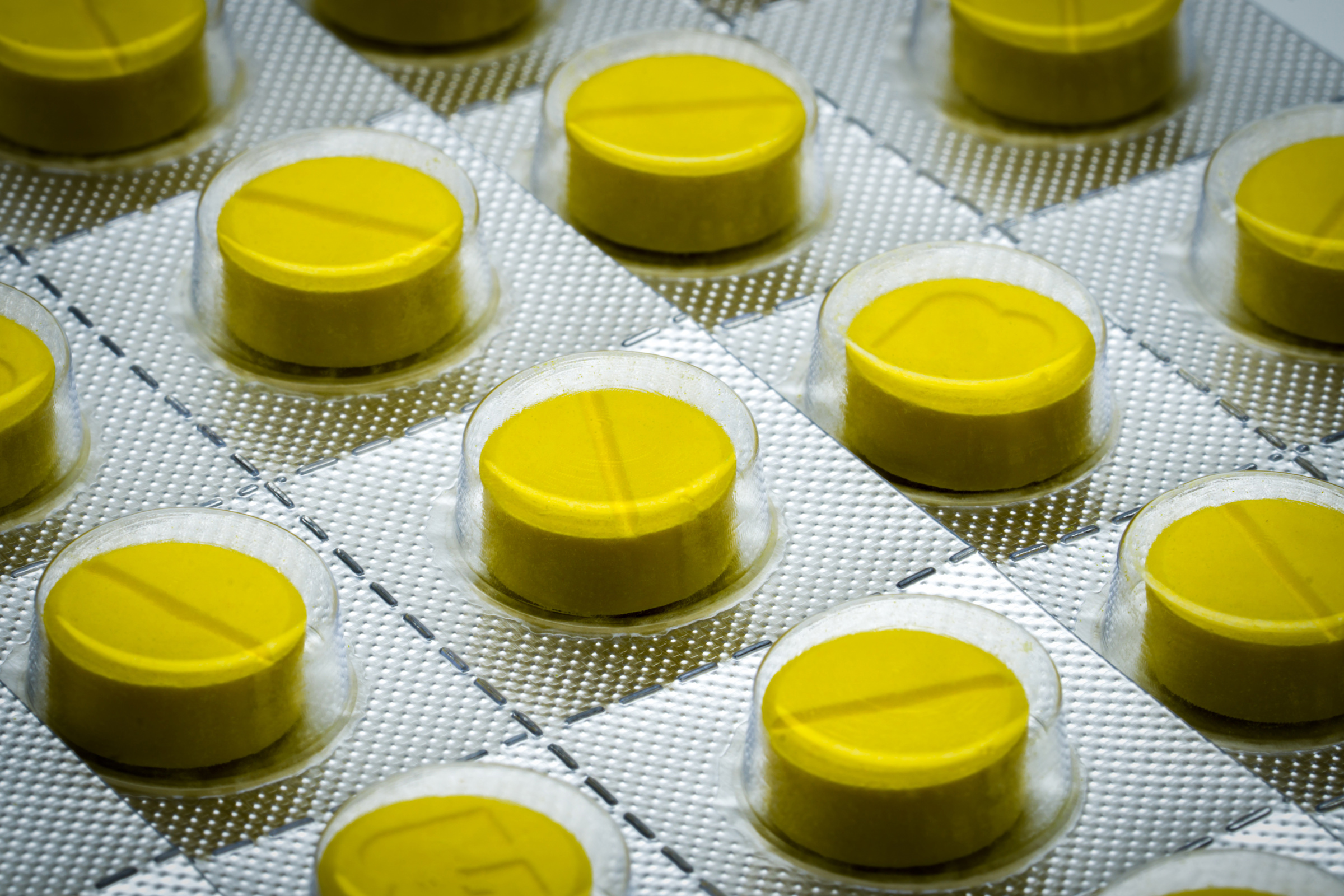 Macro Shot Detail of Yellow Tablets Pill in Blister Pack. Full F