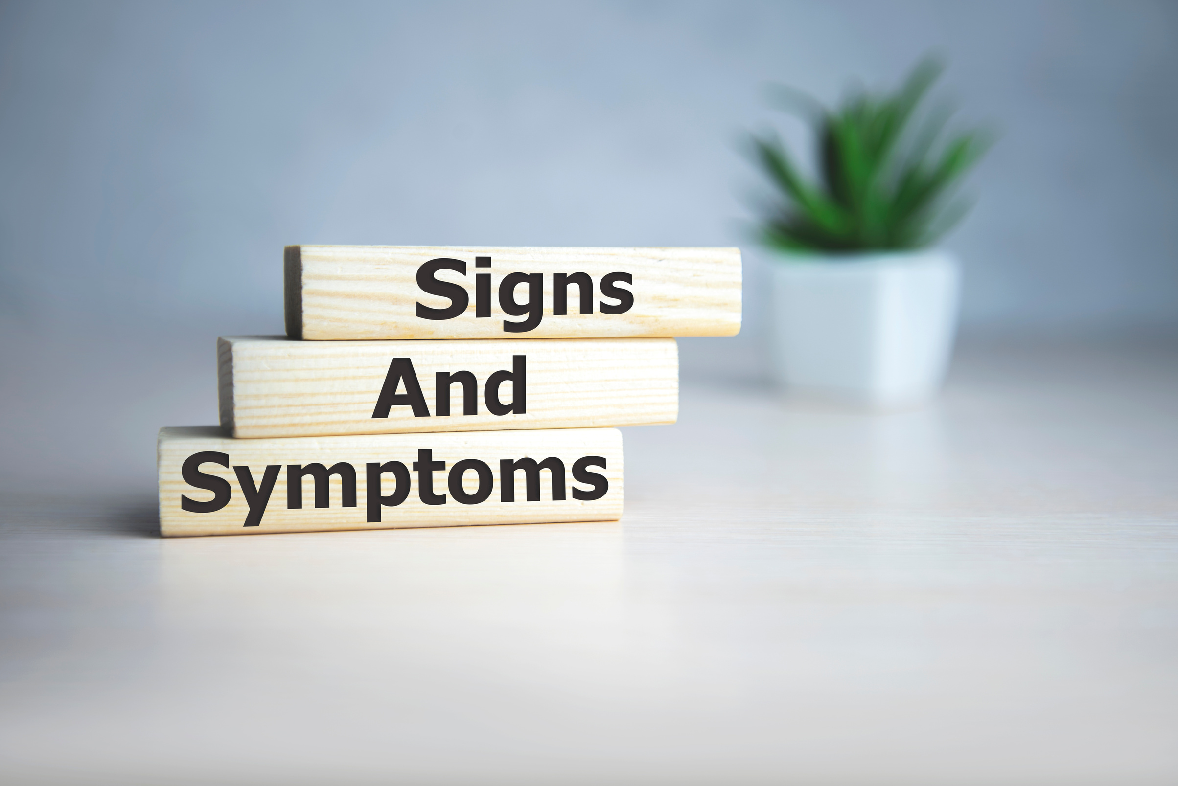 text Signs and SYMPTOMS on wooden cubes, medical concept.